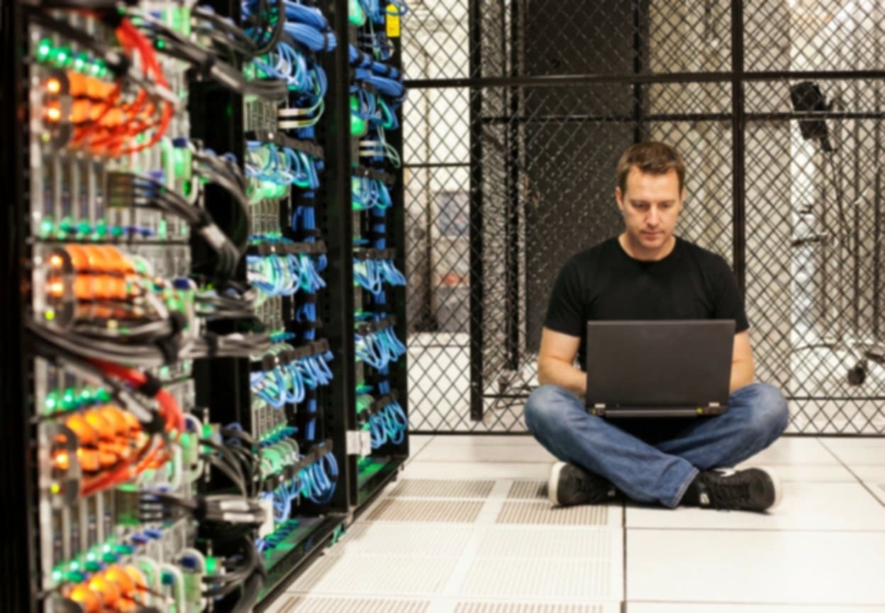 Techniker sitzt am Boden in Serverraum